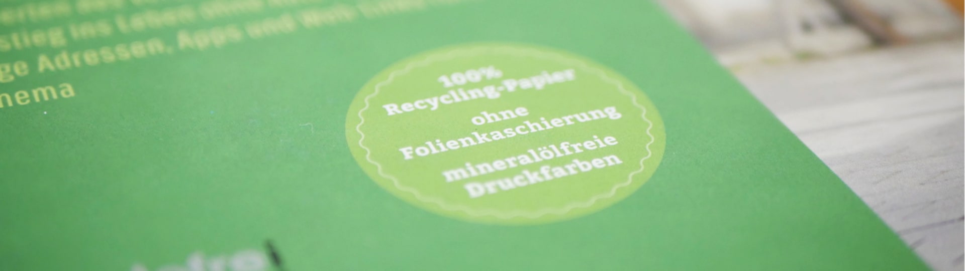 Stempel auf Buch mit Aufschrift »100% Recycling-Papier, ohne Folienkaschierung, mineralölfreie Druckfarben«