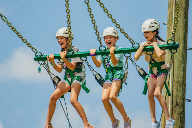 Three campers on a giant swing having fun