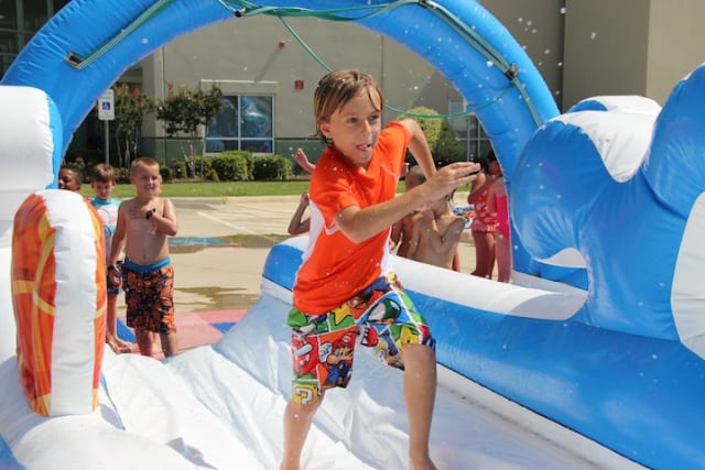 Boy runs down slip-in-slide at Fellowship of the Parks.