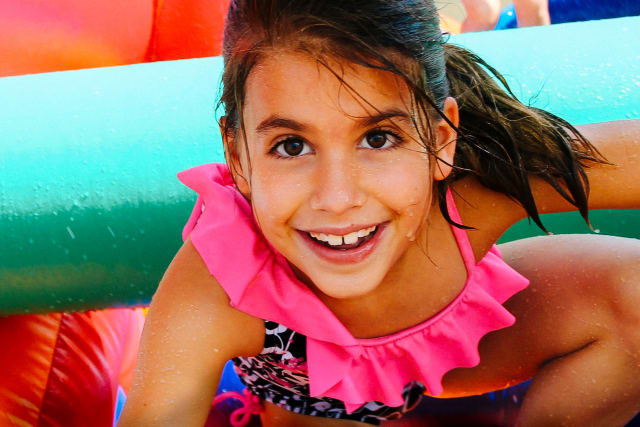 Camper slides under a bar on the obstacle course