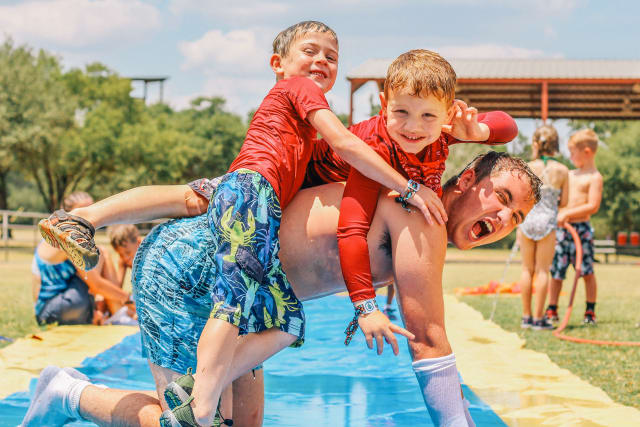 Boys tackle counselor in an outdoor slip 