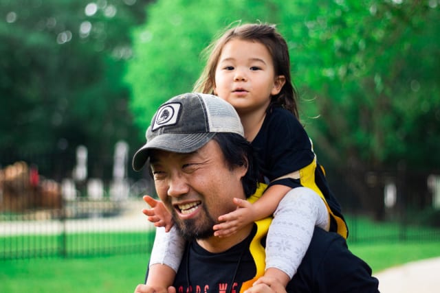 daughter riding on father