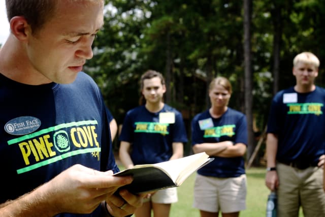 Pine Cove counselor reading the bible