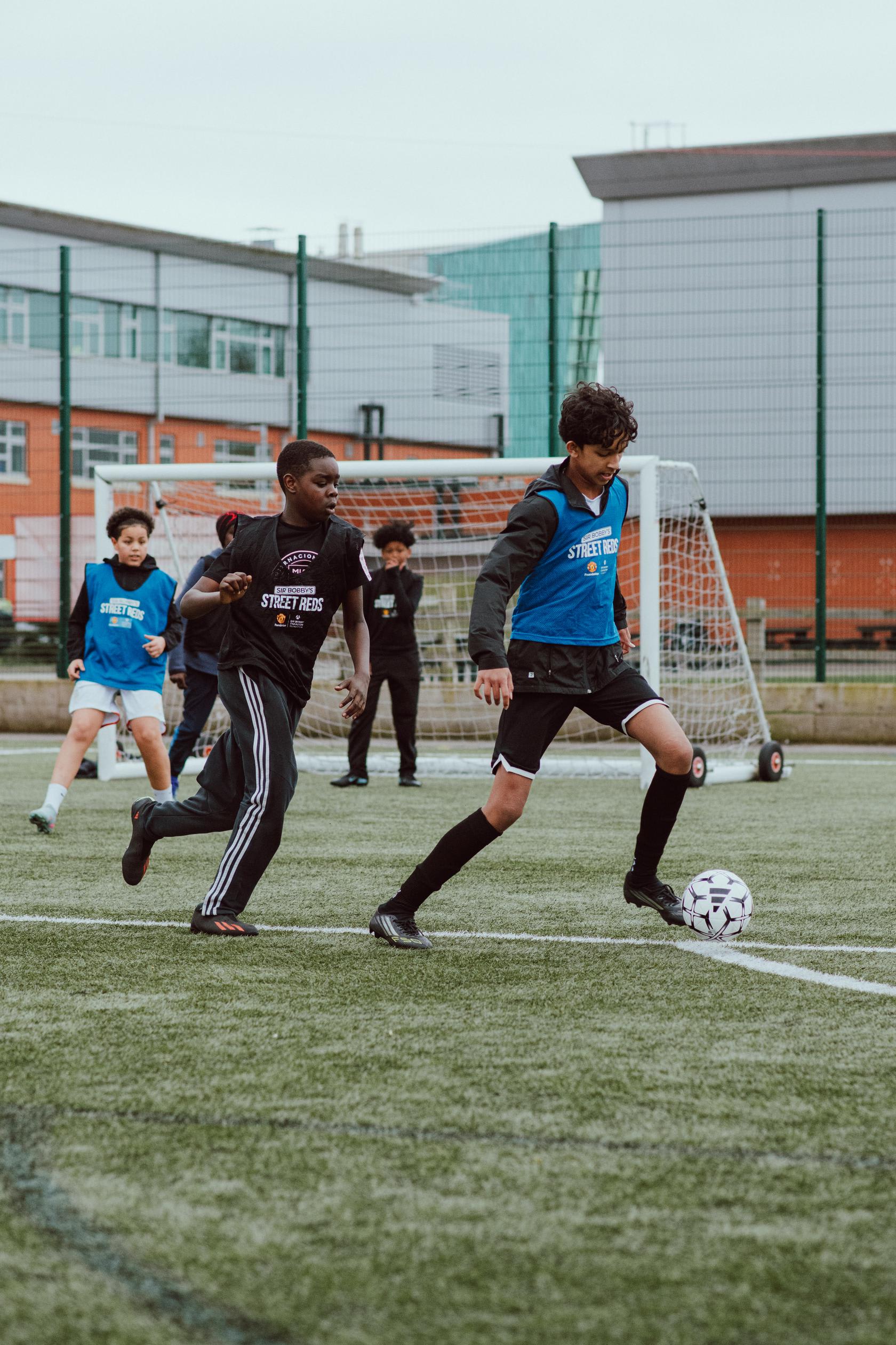 Young people playing football at a Street Reds session