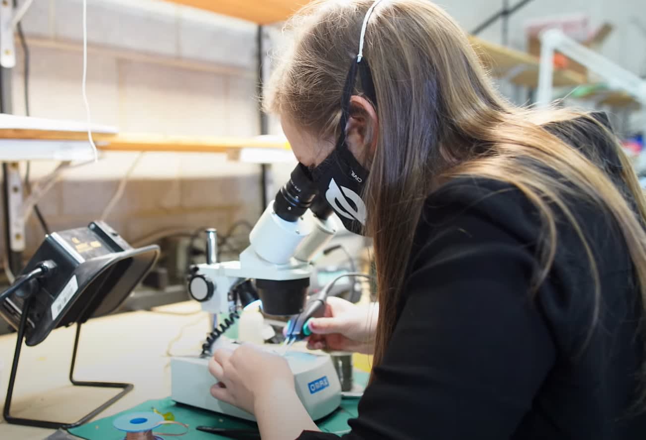 A ZeroKey engineer inspecting hardware under a microscope