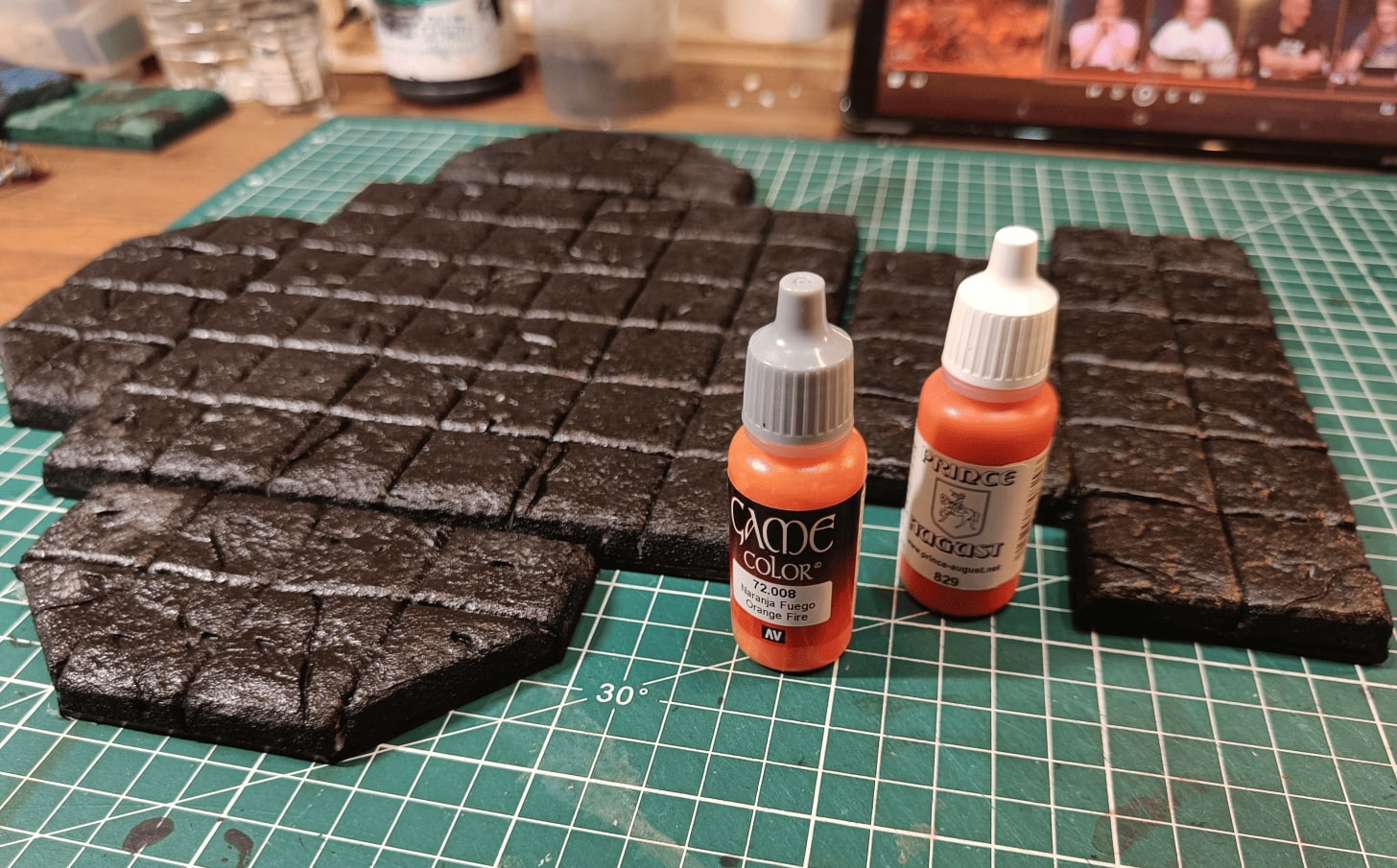 Tiles painted black with reference photo of paint tubes for color plan