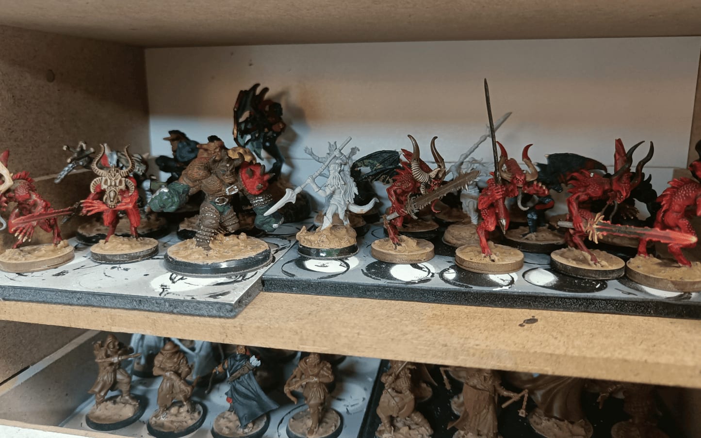 Shelves full of textured miniature bases drying overnight before priming