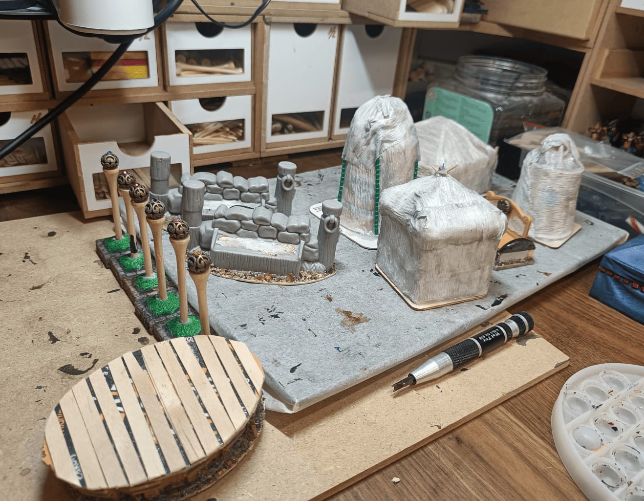Unpainted elements including toy stone walls and golf tee lampposts