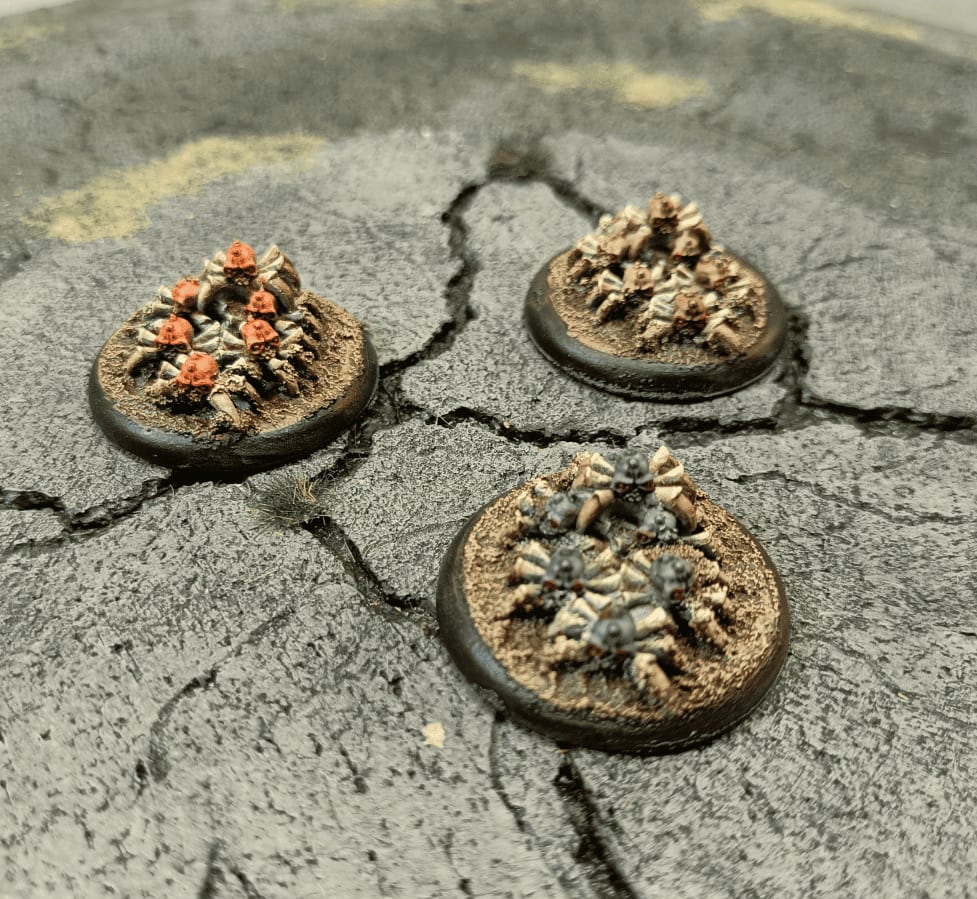 Three spider-skull variants painted in different color schemes