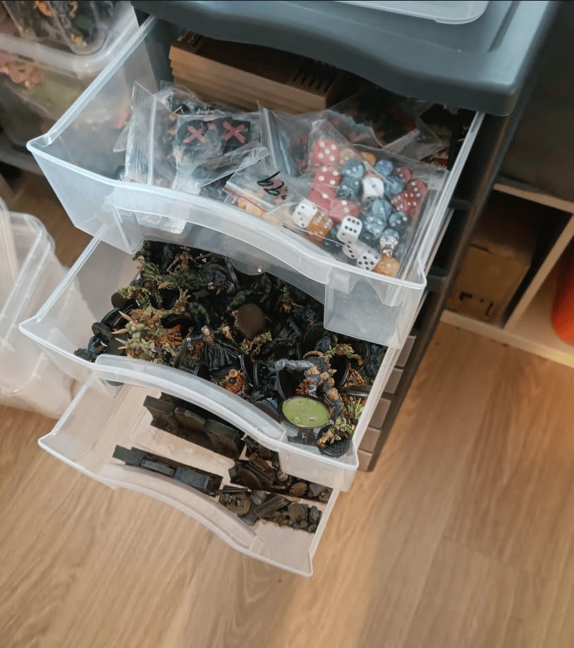 Three drawers containing game components, zombies, and barricades for Zombicide