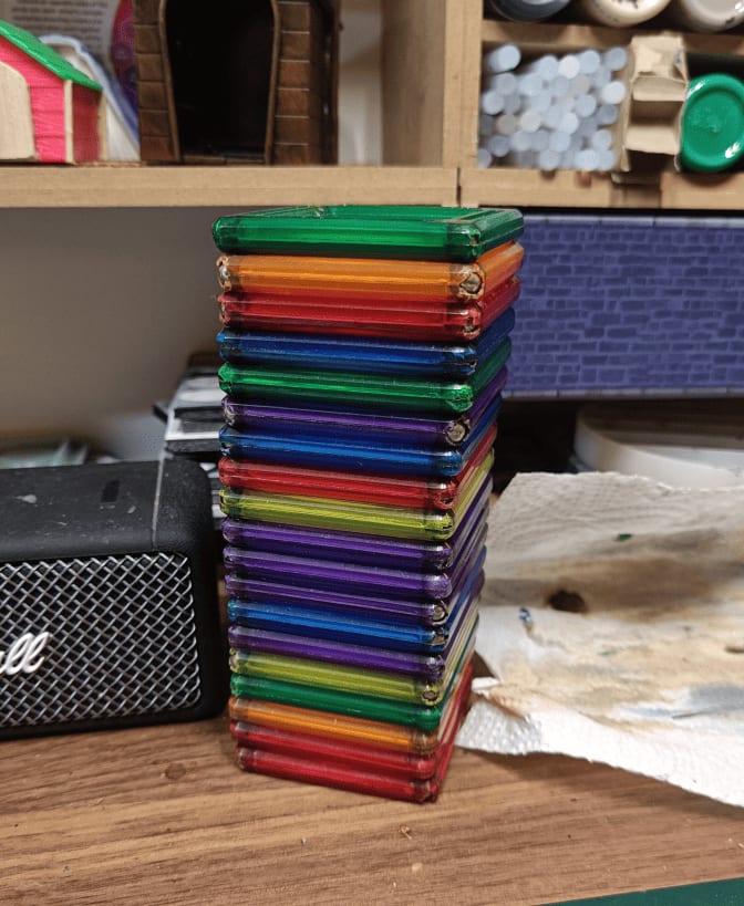 Stack of colorful plastic magnetic tiles with beads in corners showing wear