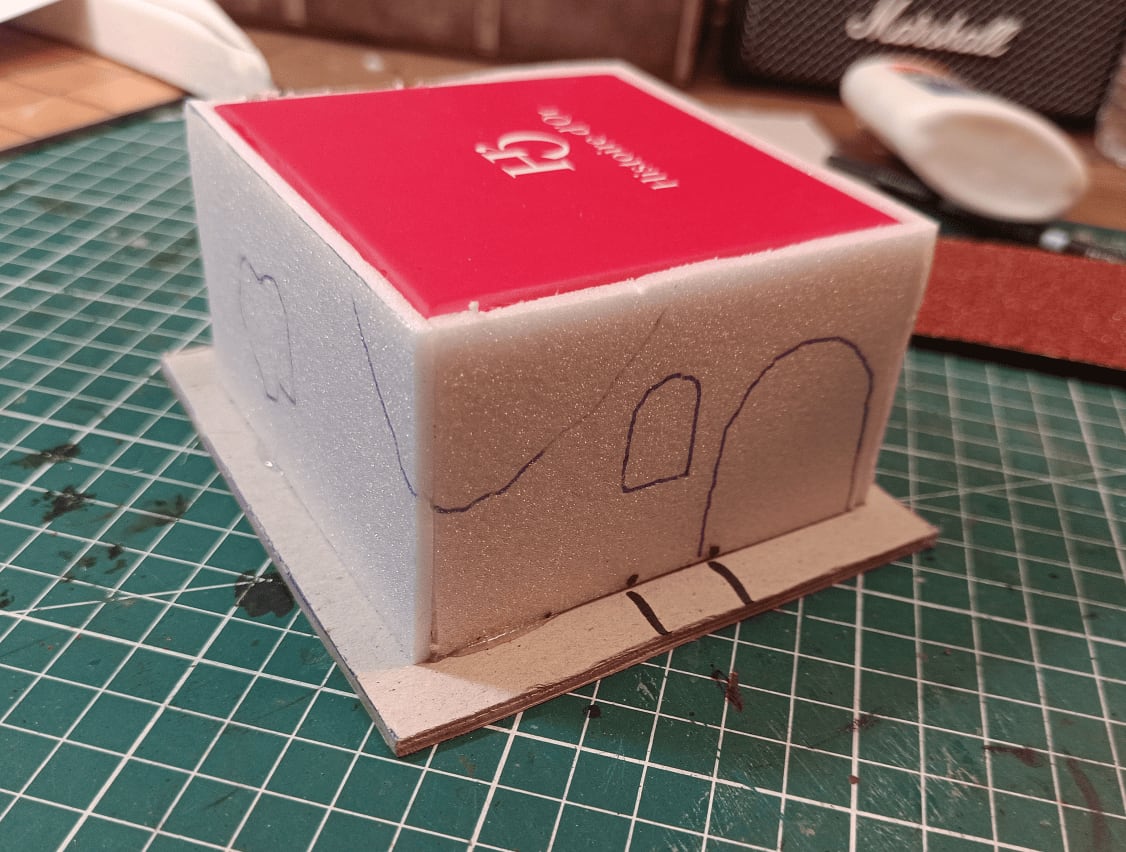 Wall with marked holes showing where to carve foam and draw bricks