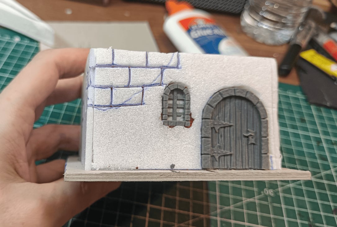 Carved foam with doors, windows, and brick texture visible through holes