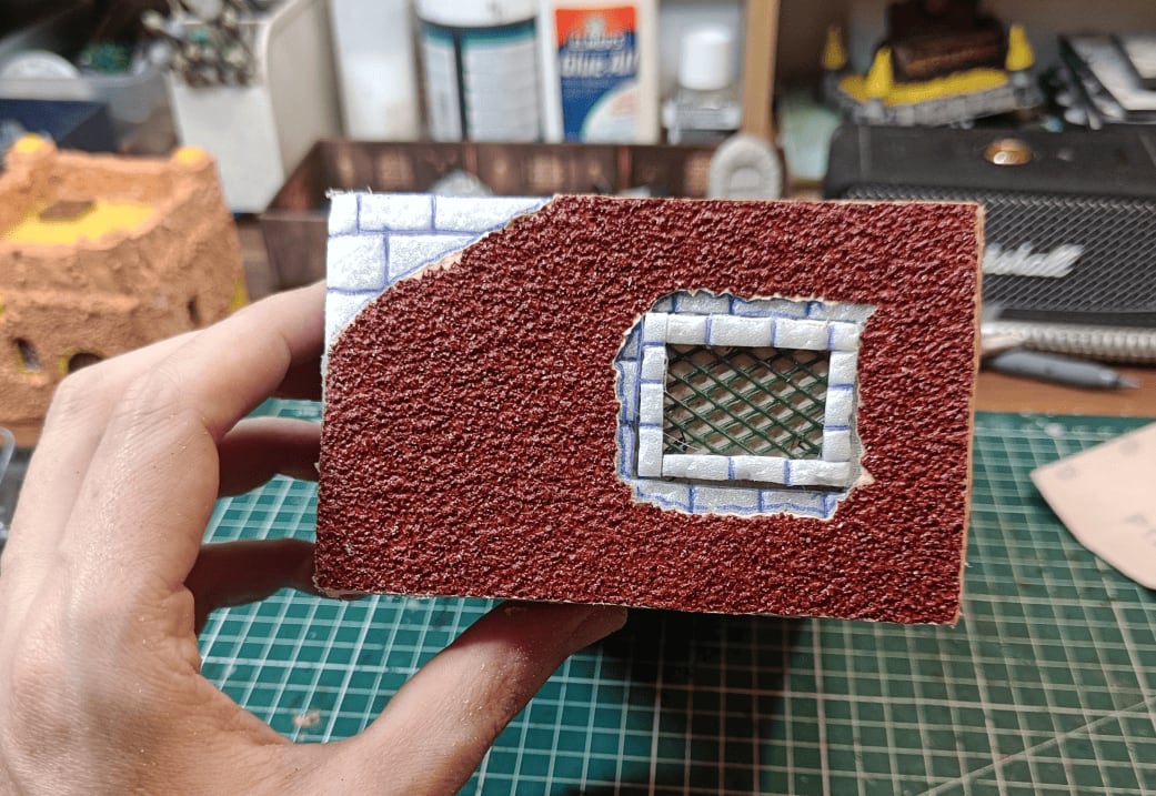 Back of building showing torn sandpaper around window from dimension mistake