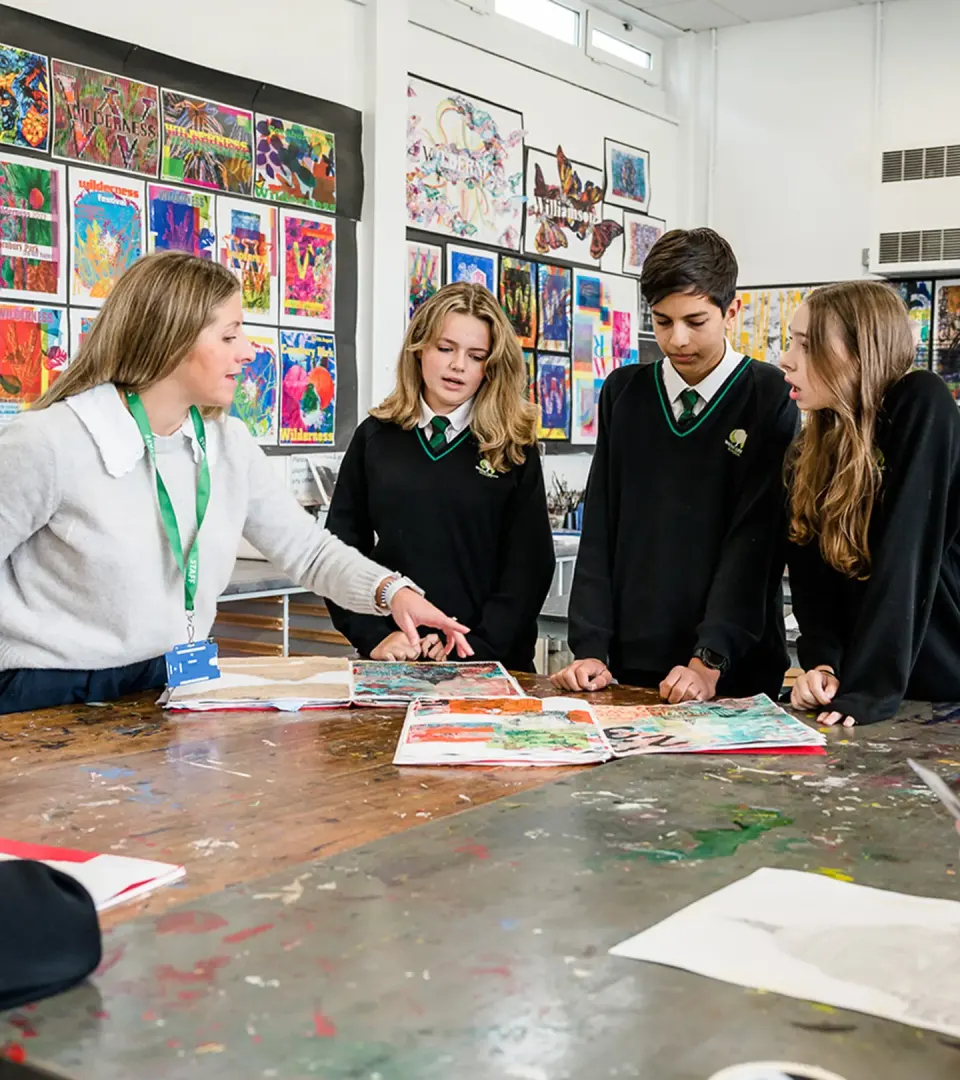 Image of students and a teacher discussing work