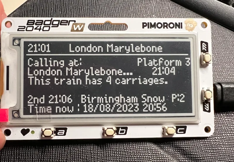 Front view of the eink badger 2040 W display, showing arrival information.