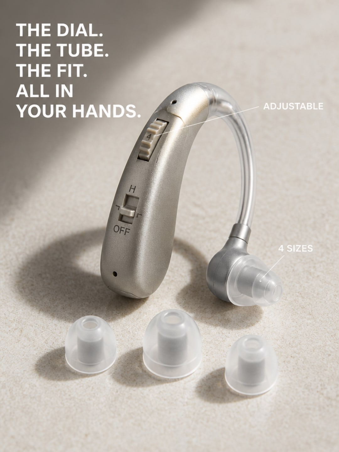 Macro close-up of Audexa behind-the-ear unit showing top-mounted volume dial, receiver tube, and four silicone dome sizes in ascending diameter