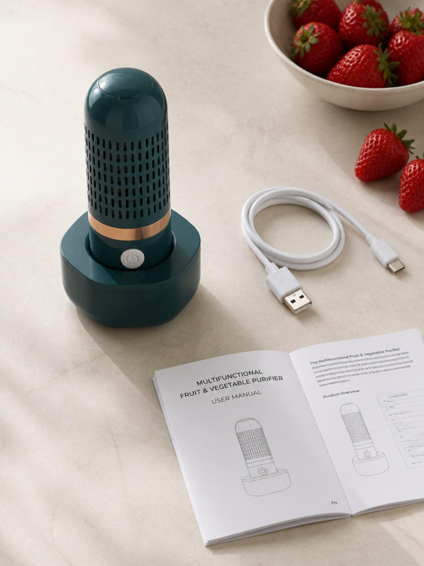 OZANIA puck food purifier with charging base, USB cable, English user manual, and fresh strawberries arranged on a light kitchen countertop — full product flatlay