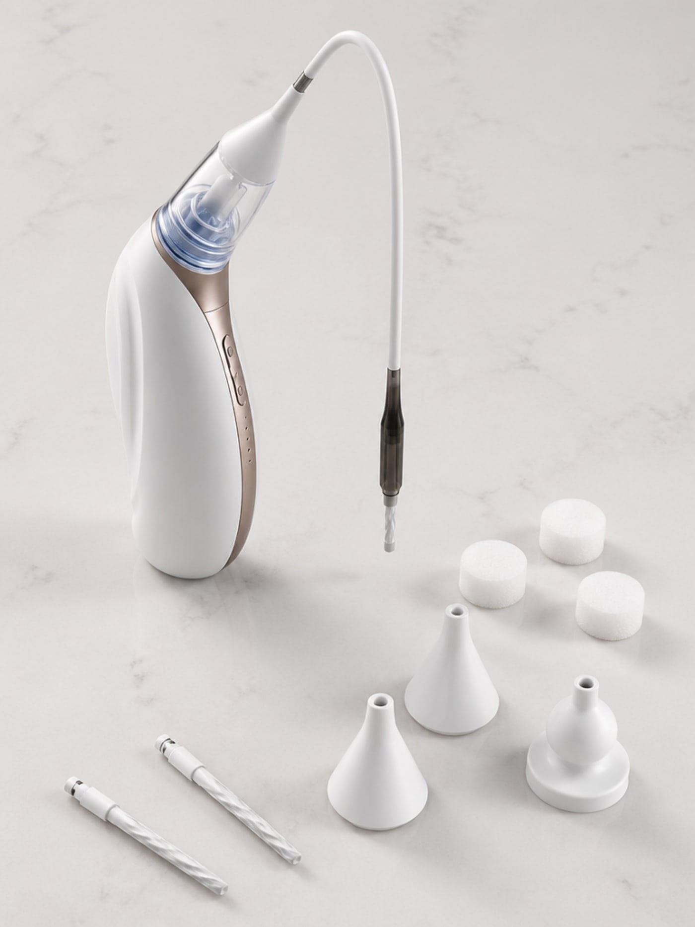 Vacurio device and silicone tip attachments arranged on a clean pale stone surface — the complete at-home ear maintenance set