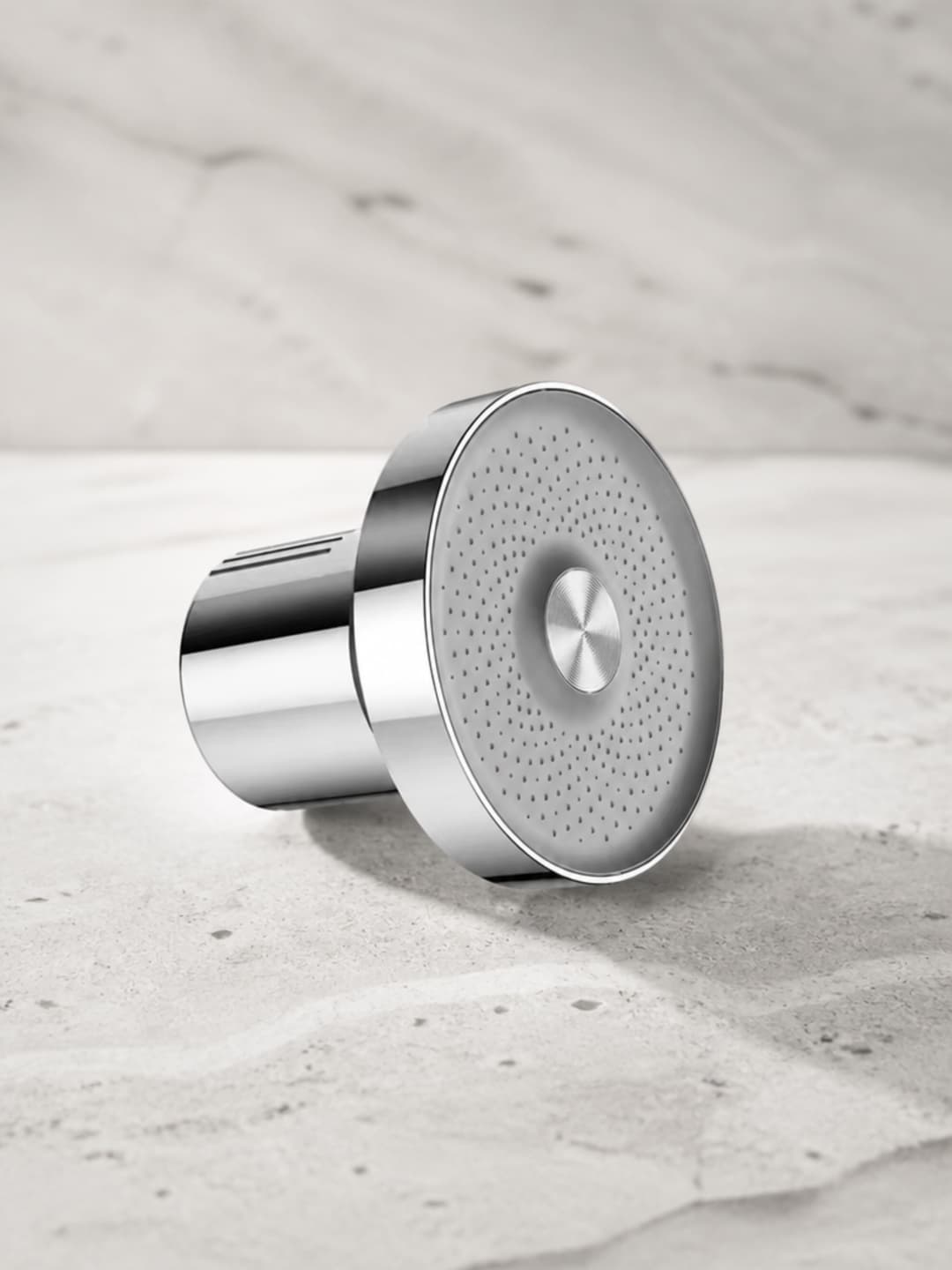 Aquava filtered shower heads in silver and matte black standing upright on a pale stone surface alongside the replaceable filter cartridge — the complete product lineup