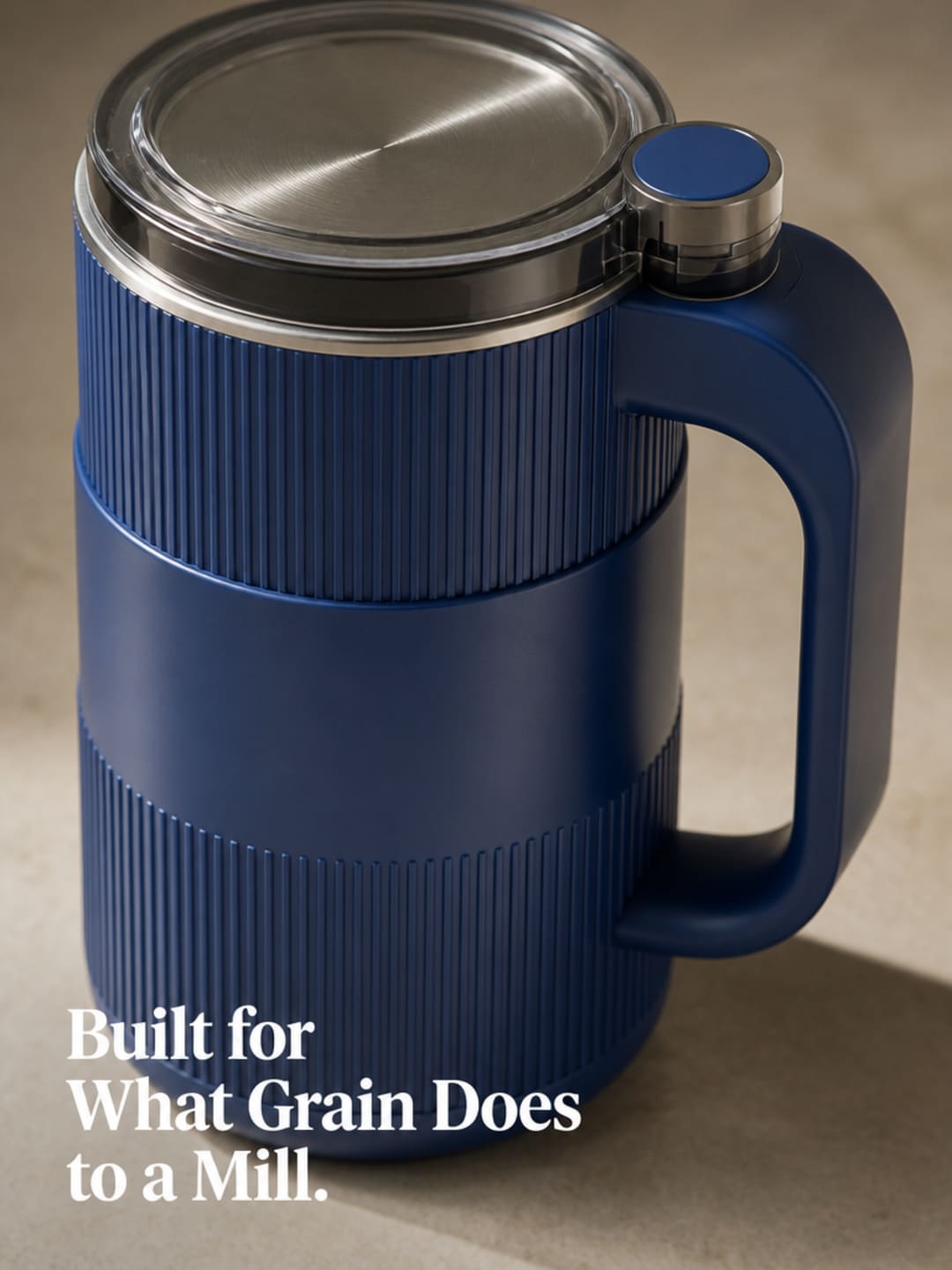 Close-up macro of the Grainbloom grain mill's 304 stainless steel body and single-button face