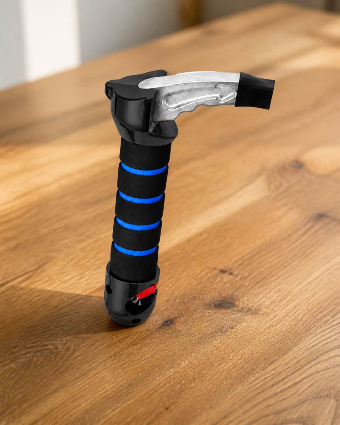 Car Aid Exit vehicle assistance handle on a warm wood surface — padded grip and metal latch tip visible