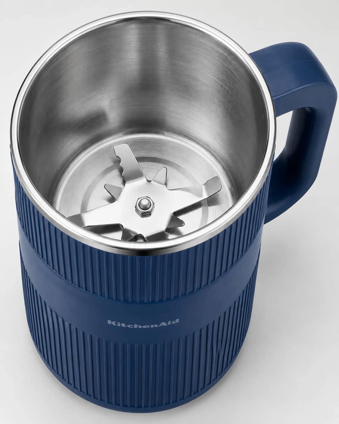Overhead view into the open GRAIN BLOOM mill showing stainless interior and star-shaped metal blade assembly