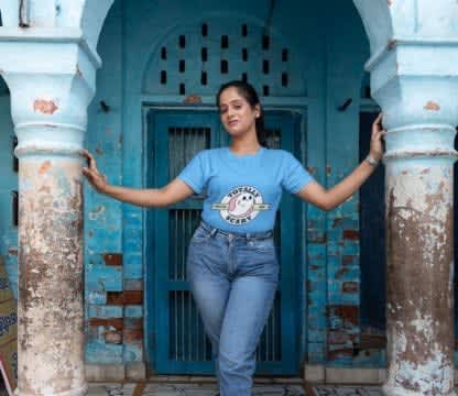 An Indian young woman wearing blue in an antique blue building 