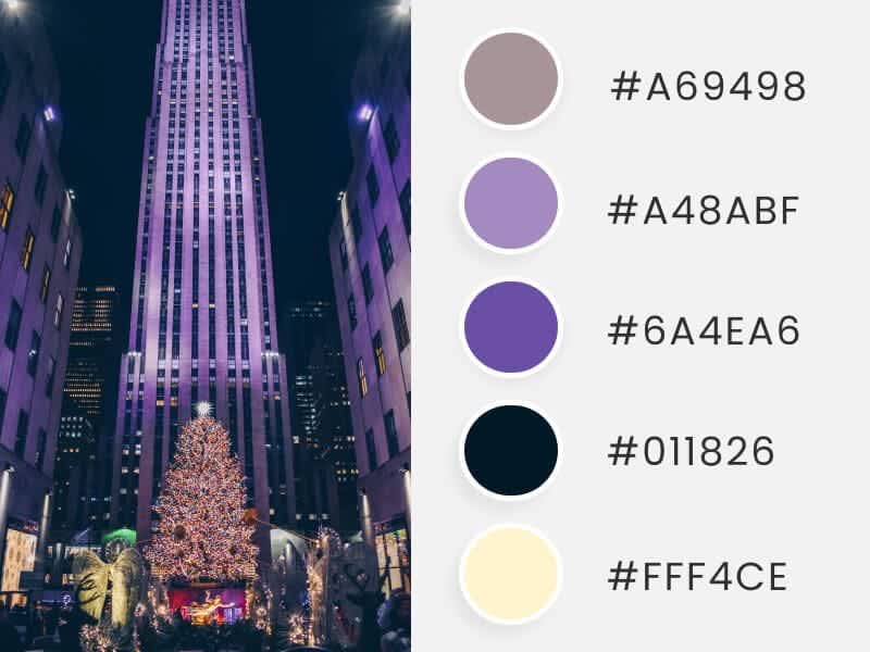 A photograph showing an imposing new york building at night and on christmas eve, accompanied by colored circles showing the corresponding hexadecimal codes of the main image. 