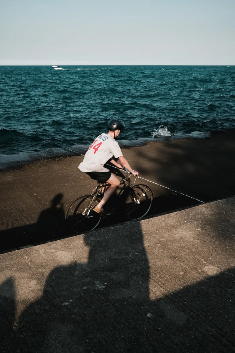Cyclist riding a concrete lakefront path beside Lake Michigan in Chicago