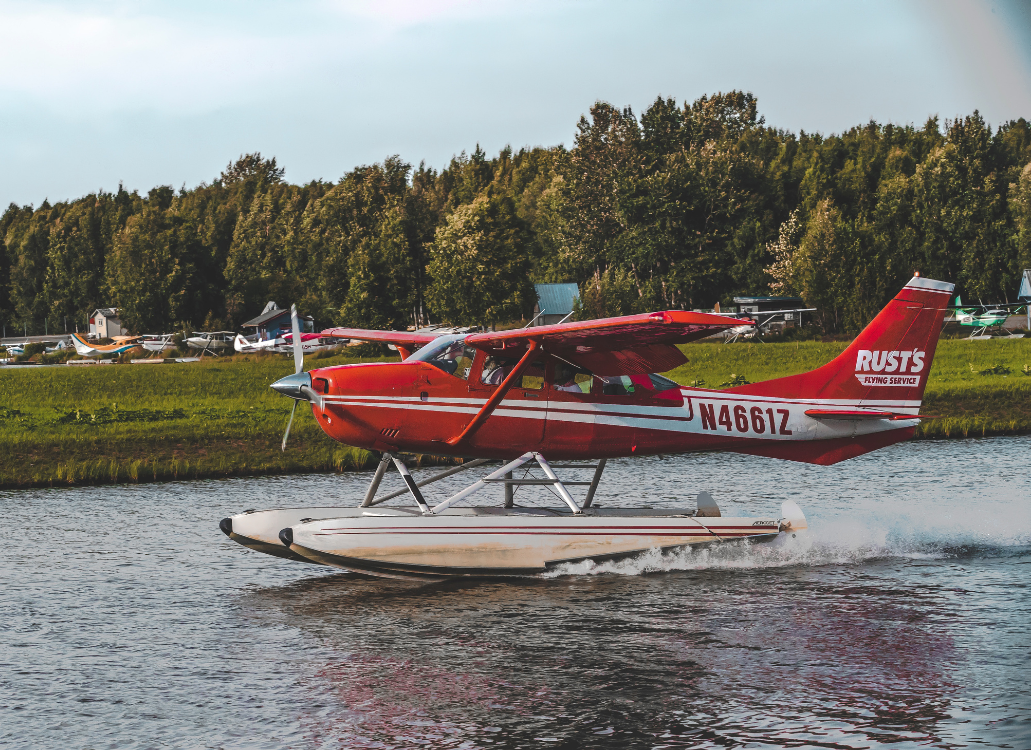 Red water plane landing in Alaskan waters.