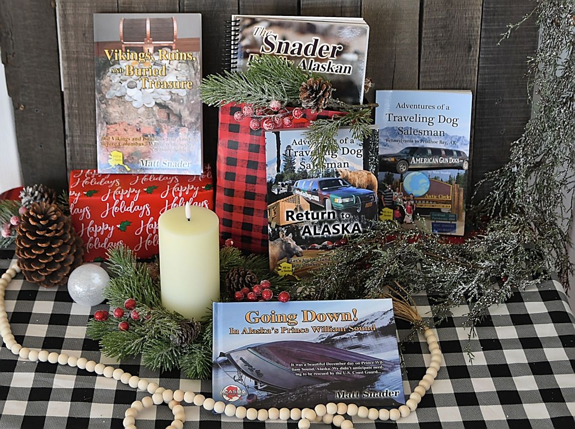 Arrangement of outdoor adventure books lined up on a table surrounded by Christmas decor.