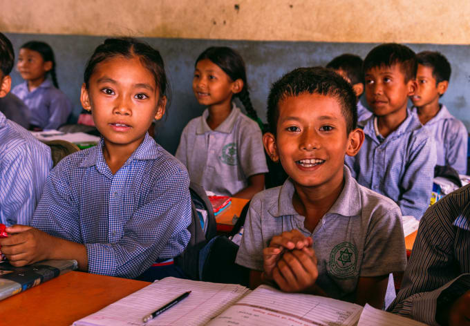 Smiling students in uniform at their desks