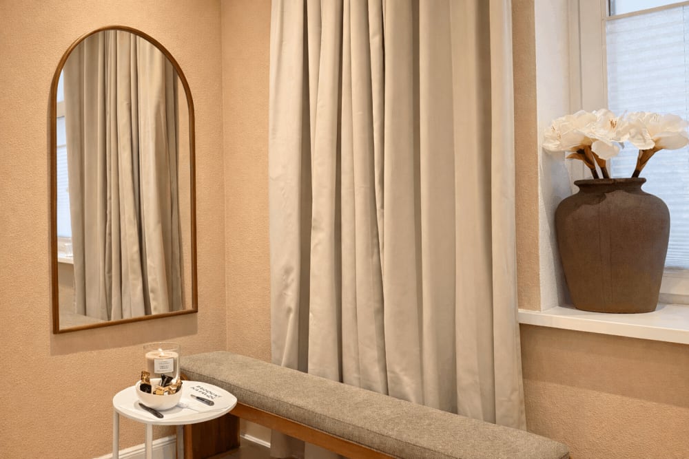 Lounge-Ecke mit Spiegel und Blumen im The Glow Theory