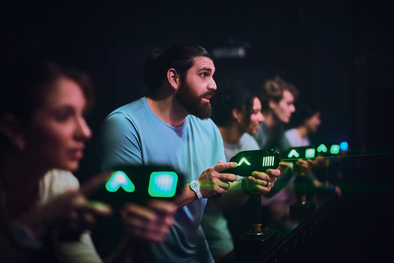 A group holds glowing symbol panels in the Mega Laser room.