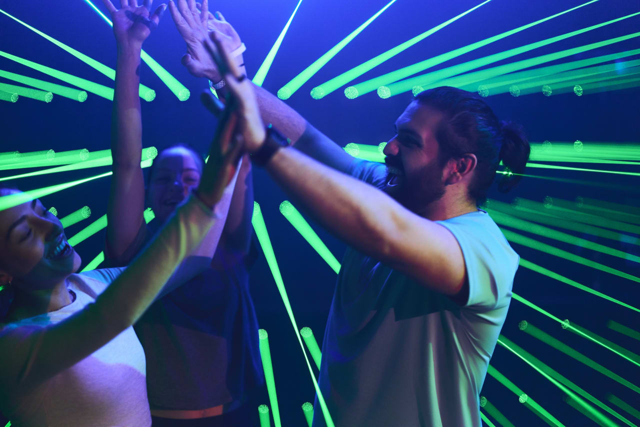 Players celebrate with a high five among the green laser beams.