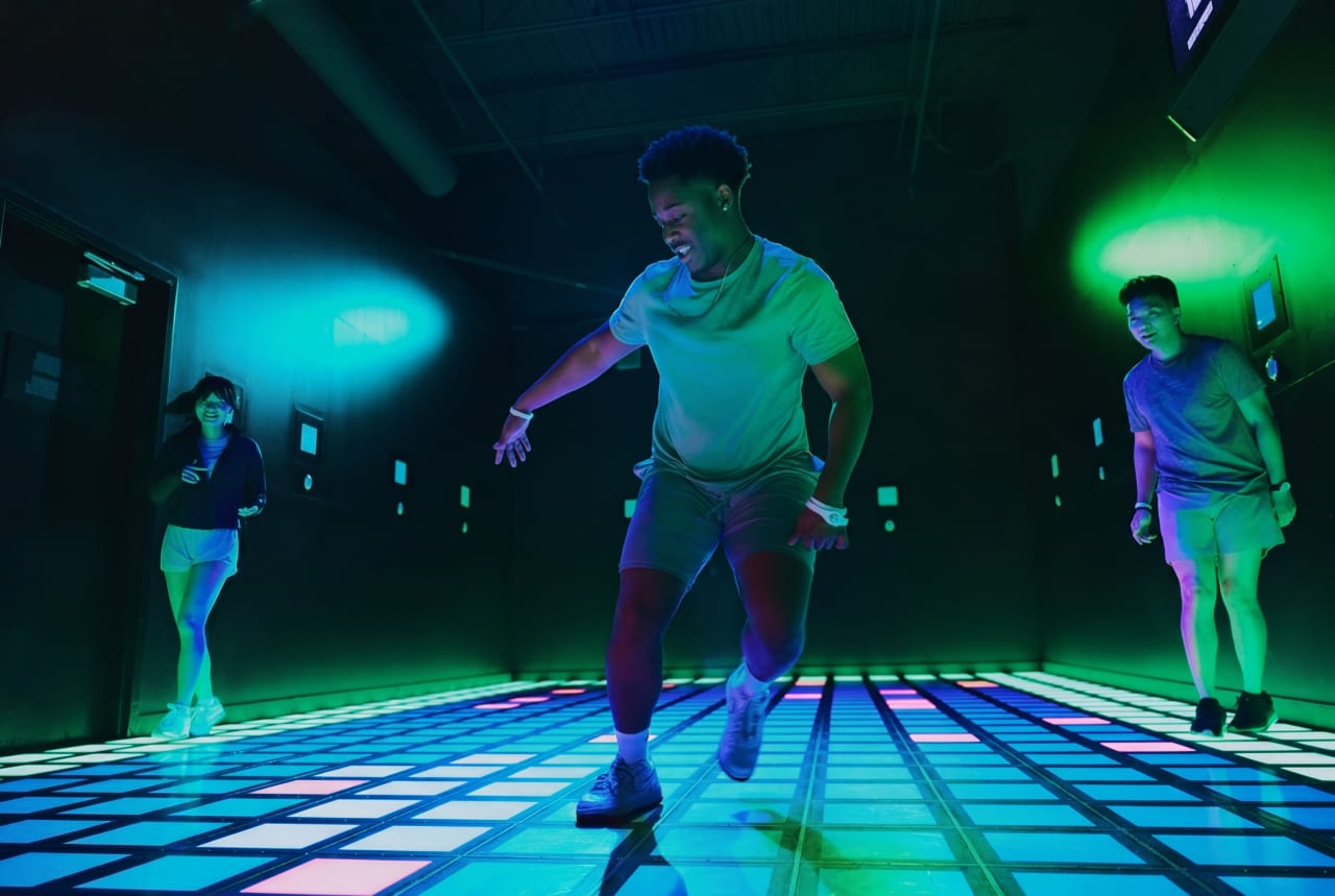 A player sprints across the Mega Grid's illuminated floor.