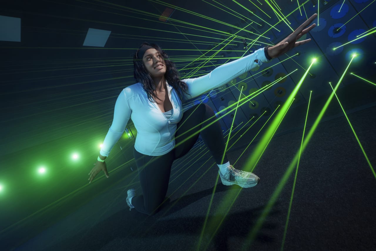A player reaches through a burst of green laser beams.