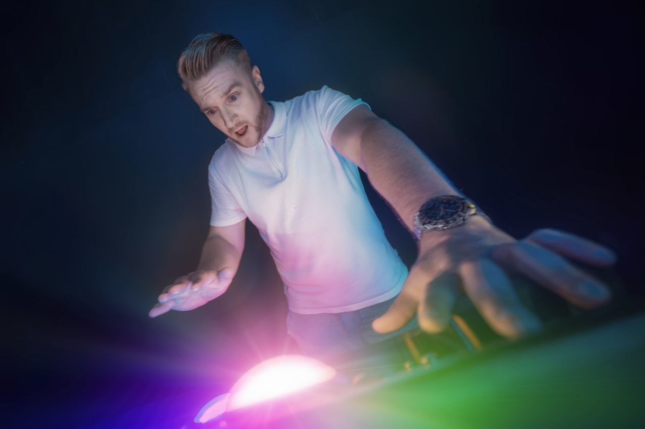 A player reaches down toward a glowing light on the floor.