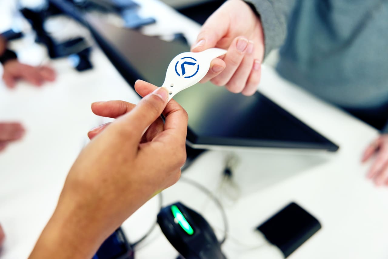 Close-up of an Activate wristband being handed to a guest.