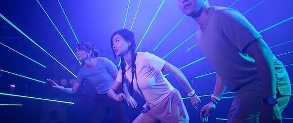 A large group dodging laser beams inside an Activate game room.