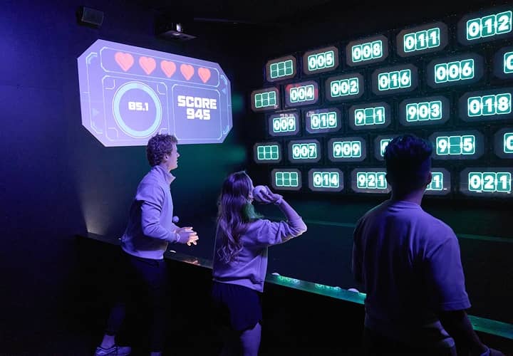 Players checking their results on a giant lit-up score display.