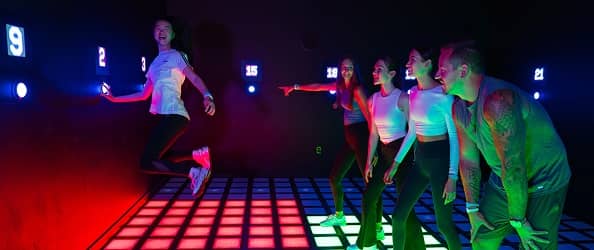 A work team competing together on a light-up game floor.