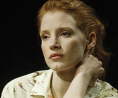Actress Jessica Chastain in Rodney's Wife. Chastain, a white woman, wears a pale yellow top. Her hair is pushed back and she looks pensive.