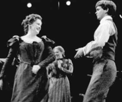 Black and white photo of actors Blair Brown, Emily Skinner, and Dashiell Eaves in James Joyce's The Dead. They wear Victorian era clothing and dance.