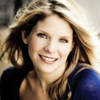 Portrait of actress Kelli O'Hara, wearing an indigo long sleeve top.