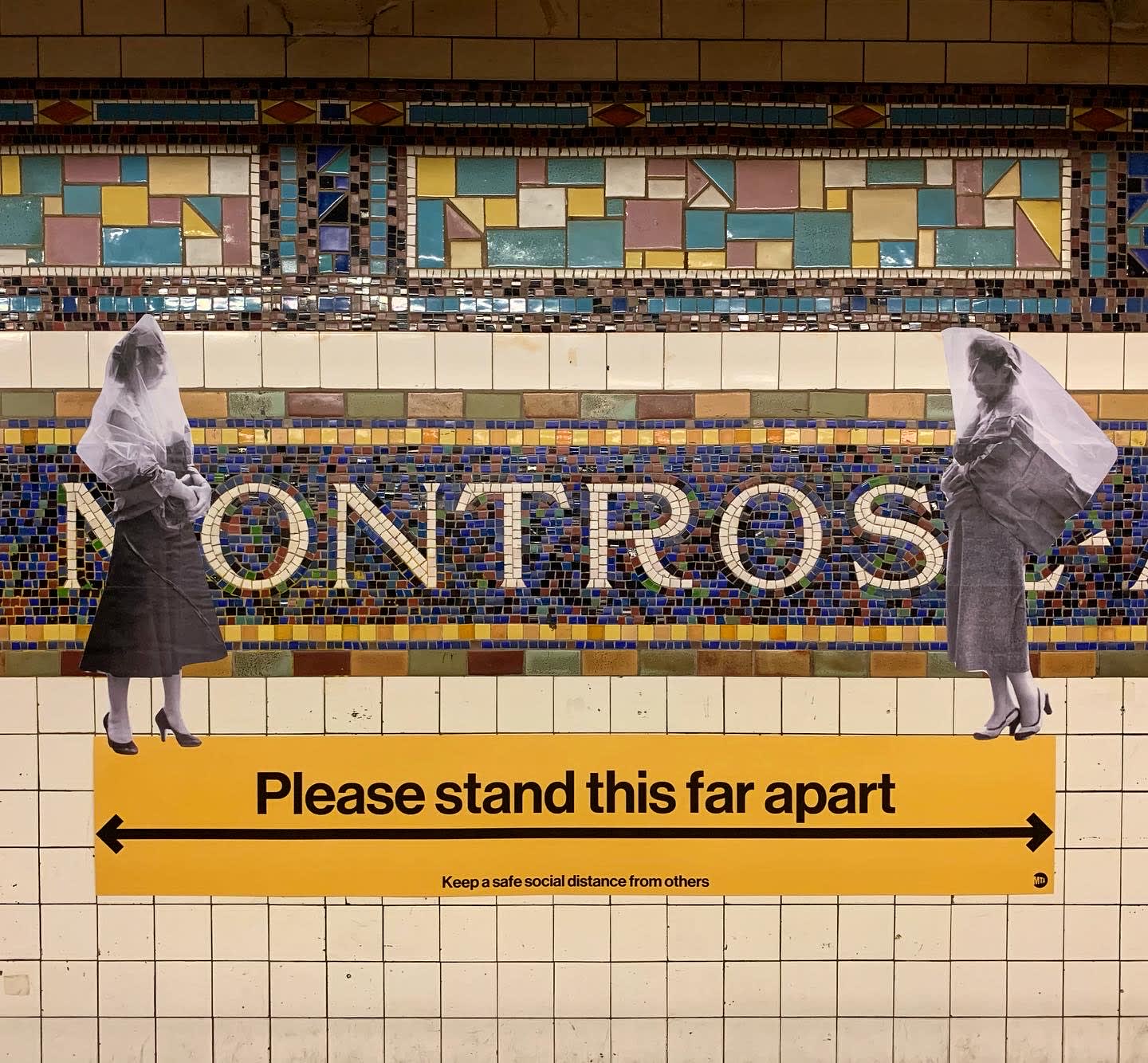 Black and white cut outs of two women stand at opposite ends of a yellow 'Please stand this far apart' sign inside Montrose subway station