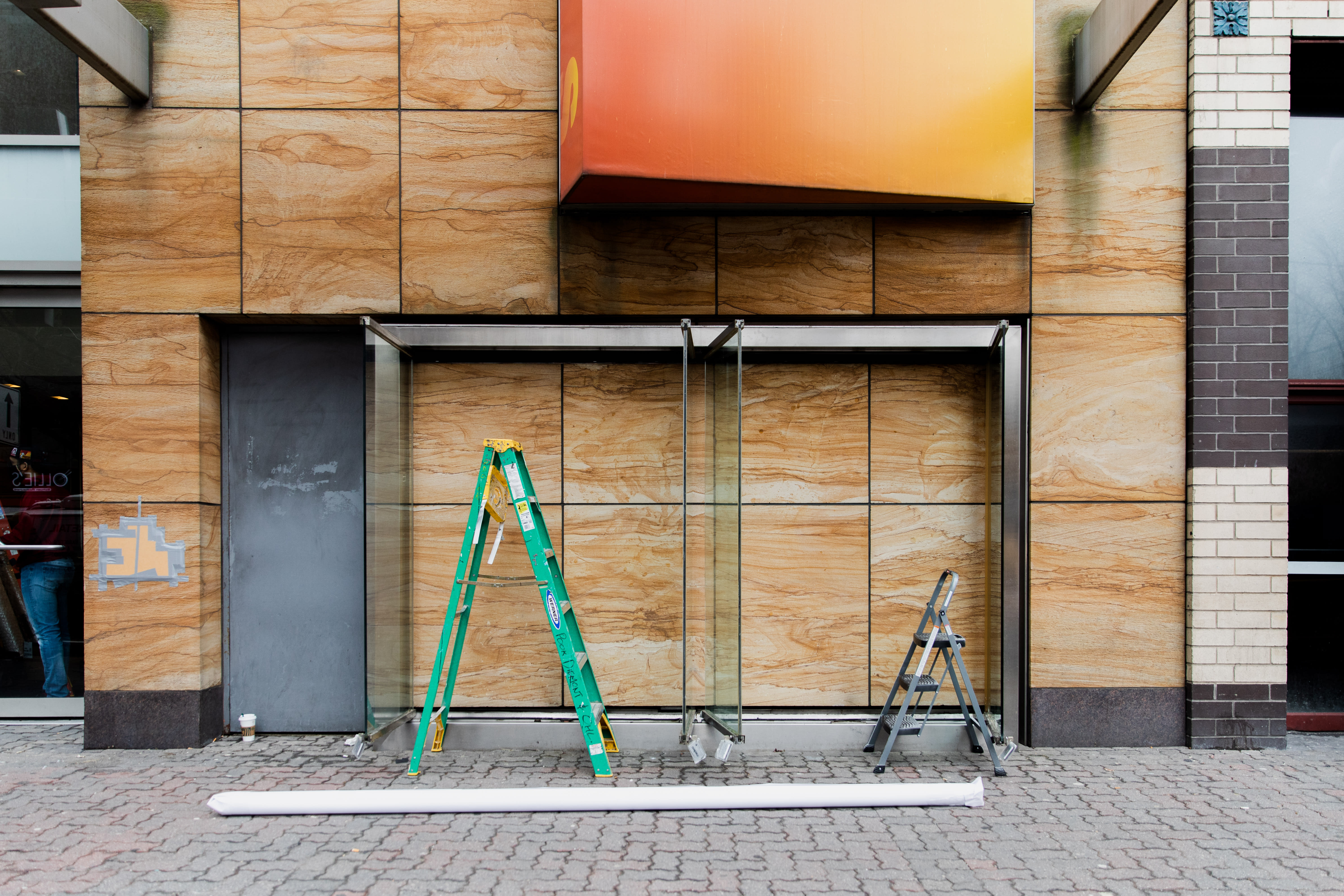 Image of an early 20th century soldier, crouching while wearing a gas mask, is pasted over the right side of an American Eagle ad. On the left side the same ad, a young male model crouches in front of a scenic road on the highway.