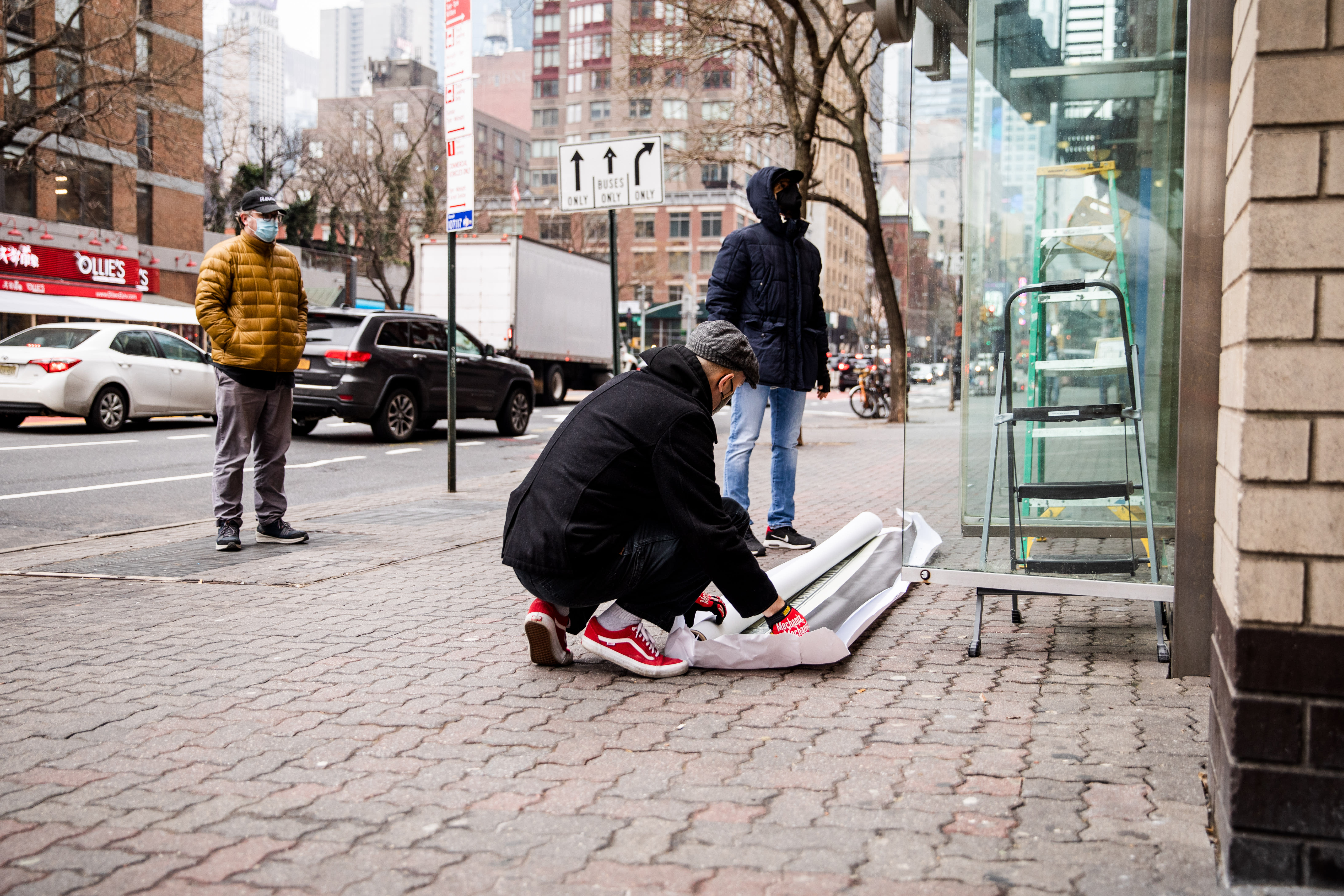 Image of an early 20th century soldier, crouching while wearing a gas mask, is pasted over the right side of an American Eagle ad. On the left side the same ad, a young male model crouches in front of a scenic road on the highway.