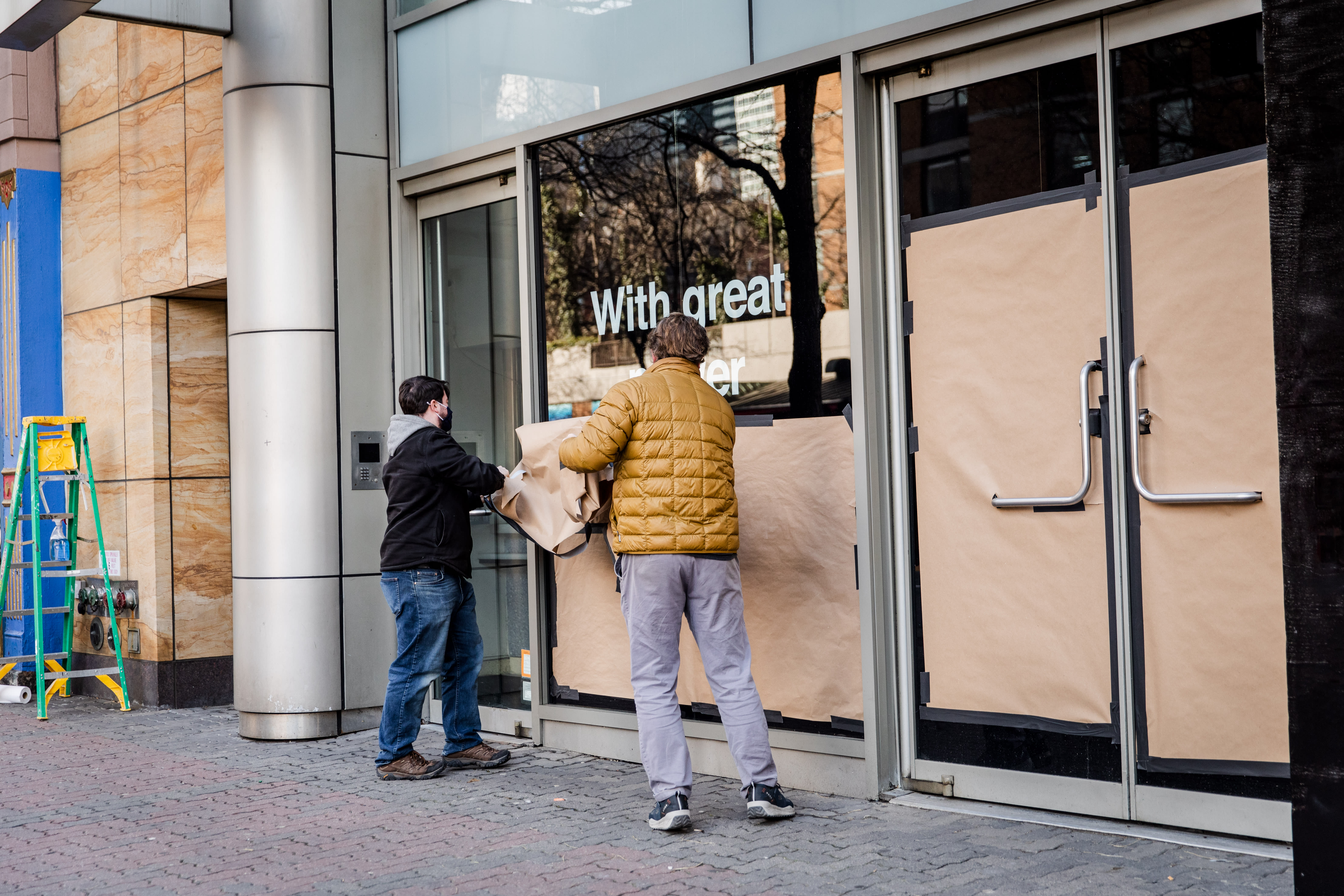 Image of an early 20th century soldier, crouching while wearing a gas mask, is pasted over the right side of an American Eagle ad. On the left side the same ad, a young male model crouches in front of a scenic road on the highway.